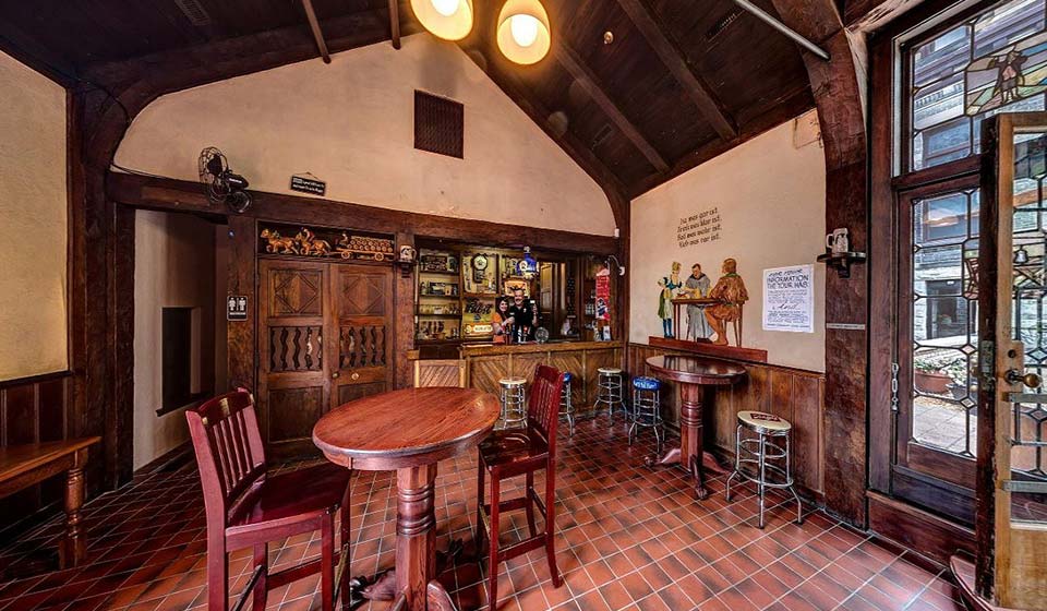 The historic Guest Center tap room with carved wood, exposed beams, and intimate tables